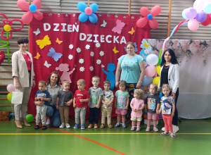 dzieci z opiekunkami , pania dyrektor i pani burmistrz stoją i pozują do zdjęcia