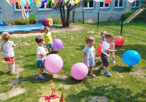 dzieci na podwórku trzymają balony