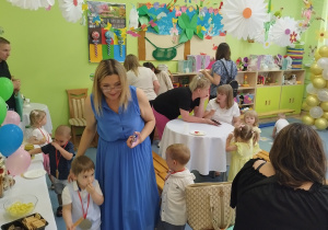 rodzice i dzieci częstują się przygotowanymi pysznościami