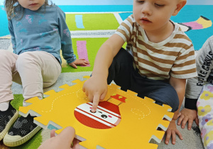 chłopiec pokazuje palcem, gdzie na obrazku są kropki