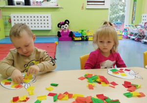 chłopiec wykleja jabłko, a dziewczynka patrzy