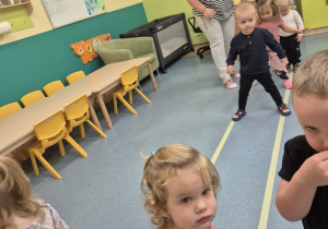 dzieci idą po dwóch liniach, opiekunka patrzy