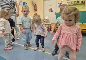 dzieci idą bokiem po linii