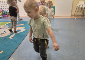 chieci chodzą jedno za drugim po linii opiekunka patrzy