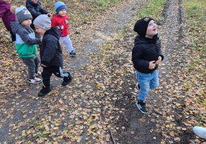 dzieci biegają, chłopiec się uśmiecha