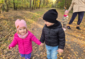 chłopiec idzie z dziewczynką, trzymają się za ręce
