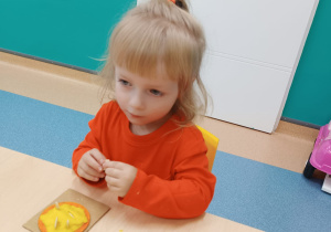 dziewczynka wykleja kółko masą dyniową