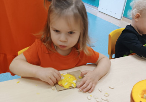 dziewczynka wciska pestki w masę dyniową