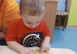 chłopiec wciska pestki w masę dyniową