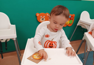 chłopiec wciska pestki w masę dyniową