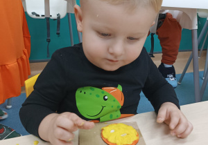 chłopiec wciska pestki w masę dyniową