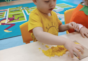 chłopiec wypełnia kółko masą dyniową