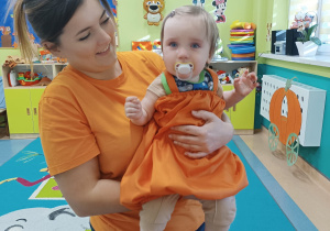 opiekunka trzyma na rękach dziecko