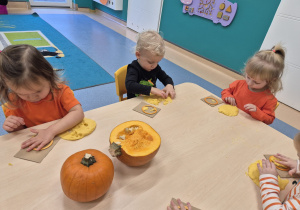 dzieci wyklejają kółka masą dyniową