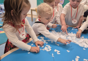 dzieci przyklejają białą bibułę