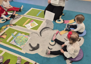 opiekunka pokazuje dzieciom ilustracje -symbole Polski