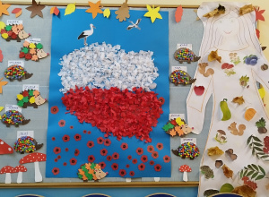 na żłobkowej tablicy wiszą prace wykonane przez dzieci: flaga Polski, Pani Jesień oraz jeże