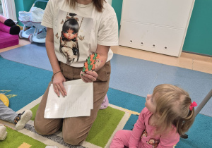 dziecko przygląda się pokazywanemu przez opiekunkę jeżykowi