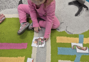 dziewczynka układa jeża z puzzli