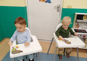 chłopcy siedzą wyklejają jeżyki kulkami