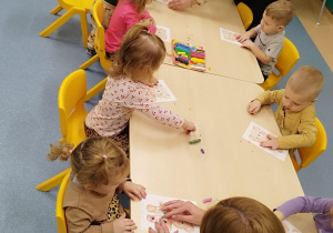 opiekunki pomagają dzieciom wykonać zadanie plastyczne