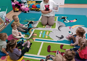 dzieci siedza i patrzą i słuchają opowaidania