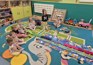 dzieci siedzą na dywanie