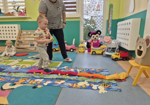 chłopiec idzie do misia w ręce trzyma rybkę