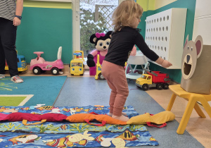 dziewczynka wkłada rybkę w pyszczek misia