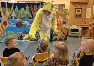 aktor przebrany za żabę przybija dzieciom "piątkę"