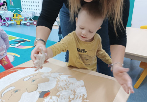 chłopiec będzie odbijał rączkę, opiekunka pomaga