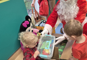 mikołaj rozdaje dzieciom prezenty