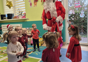 mikołaj stoi, a dzieci wokół niego