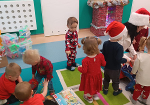 pani dyrektor na dywanie z dziećmi rozpakowują prezenty