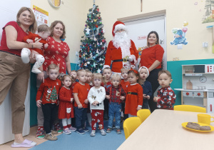 dzieci i opiekunki na zdjęciu z mikołajem przy choince