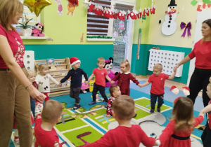 dzieci tańczą w kółeczko z opiekunkami