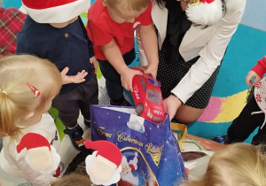 dzieci wyjmują z torby prezenty od pani dyrektor