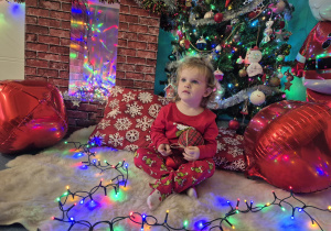 dziewczynka siedzi i trzyma bombkę