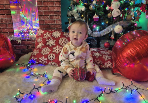 dziewczynka siedzi i trzyma bombkę