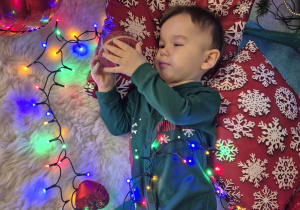 chłopiec leży i trzyma bombkę