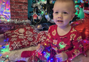 chłopiec siedzi, uśmiecha się