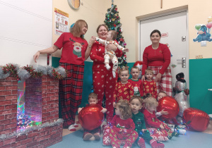 dzieci wraz z opiekunkami na tle choinki