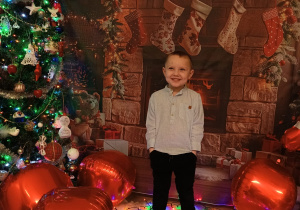 chłopiec trzyma ręce w kieszeniach , uśmiecha się