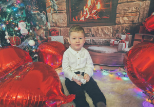 chłopiec siedzi i uśmiecha się