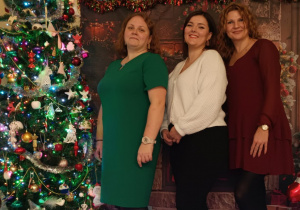 opiekunki pozują do zdjęcia przy choince, uśmiechają się