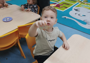 chłopiec pokazuje wykonaną pracę