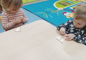 dziewczynki w skupieniu odklejają małe diamenciki