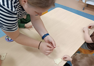 opiekunka pomaga chłopcu odkleić diamenciki