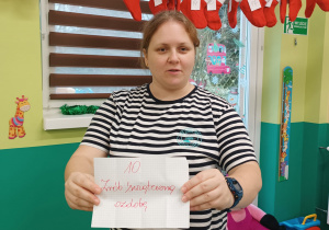 opiekunka pokazuje kartkę z napisanym zadaniem na dziś