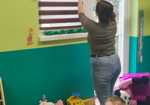 opiekunka wyjmuje ze skarpety kartkę z zadaniem na dziś